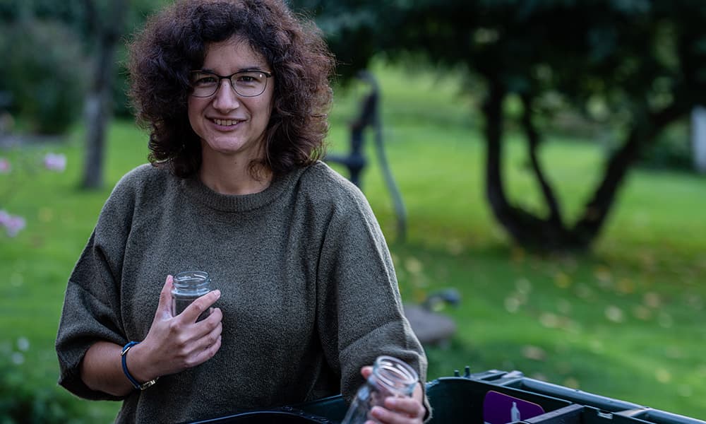 Kvinna som återvinner glas.